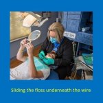 staff member sliding floss underneath a patient's braces wire