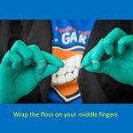 staff member wrapping the floss on their middle fingers