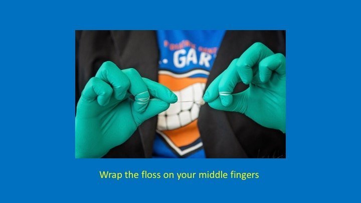 staff member wrapping the floss on their middle fingers